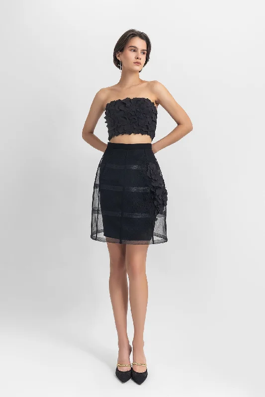 Strapless cropped-top with laser-cut details, paired with a cage-like skirt with flower details
 on the side. flowy skirt hem